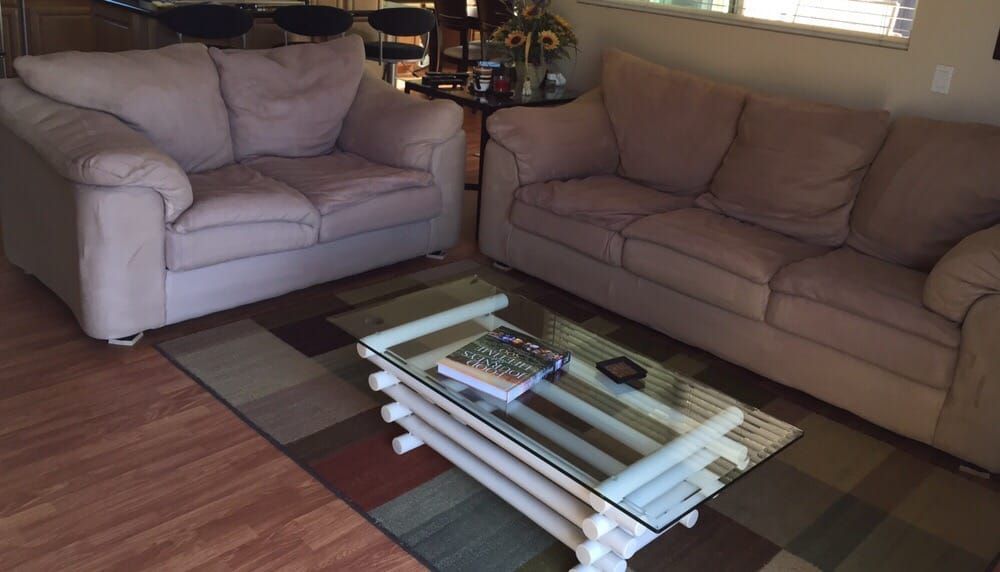 A living room with two couches and a glass coffee table