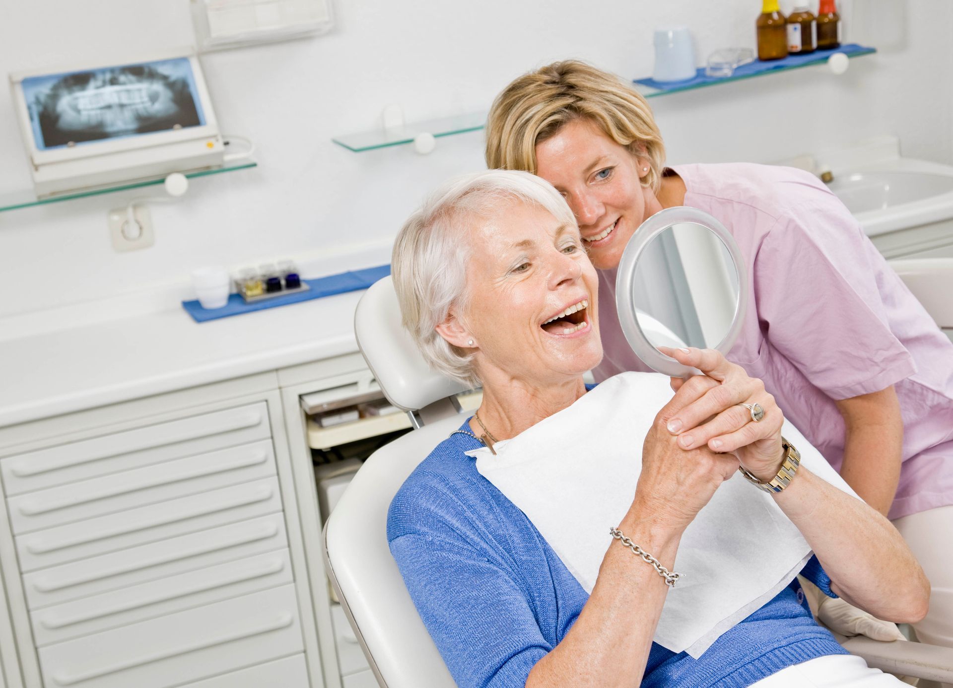 Woman at the dentist; mouth open, teeth examined with tools.
