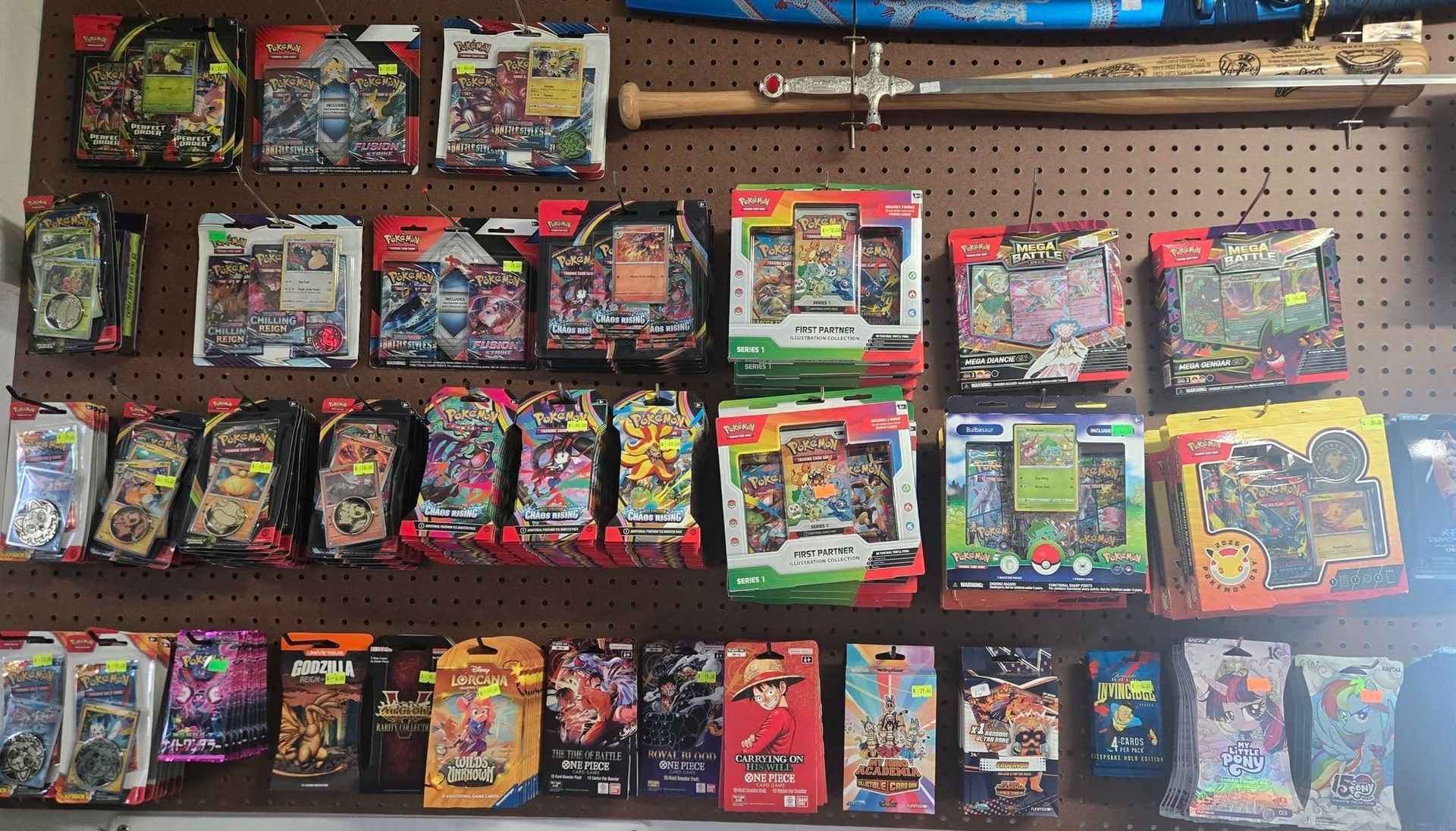 Assorted toy and game packages displayed on store shelves in rows, with colorful boxes and hanging items.