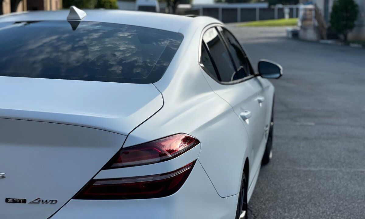 A white car is parked on the side of the road.