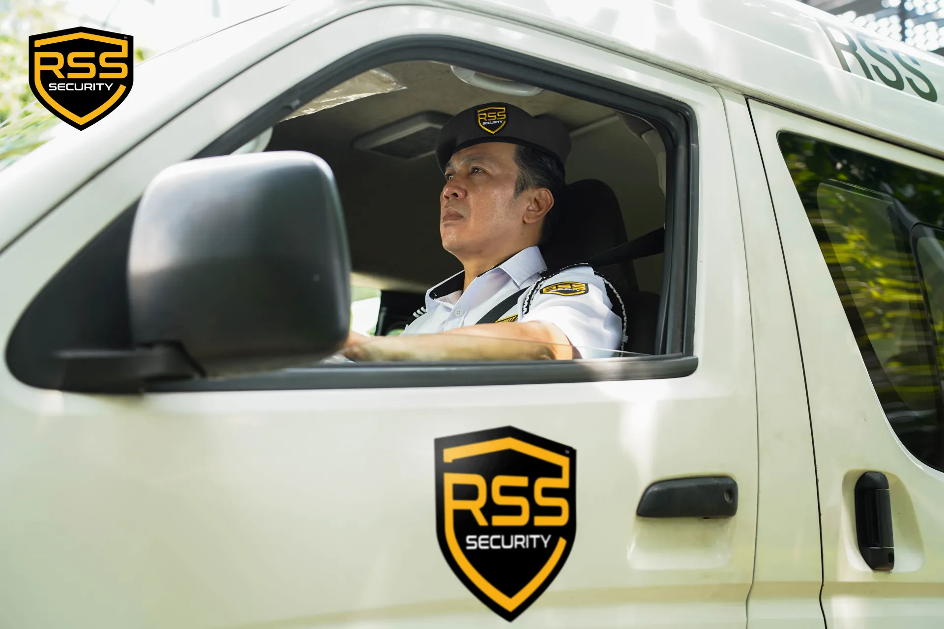 Security guard in white uniform with RSS patches and black shoulder cord.