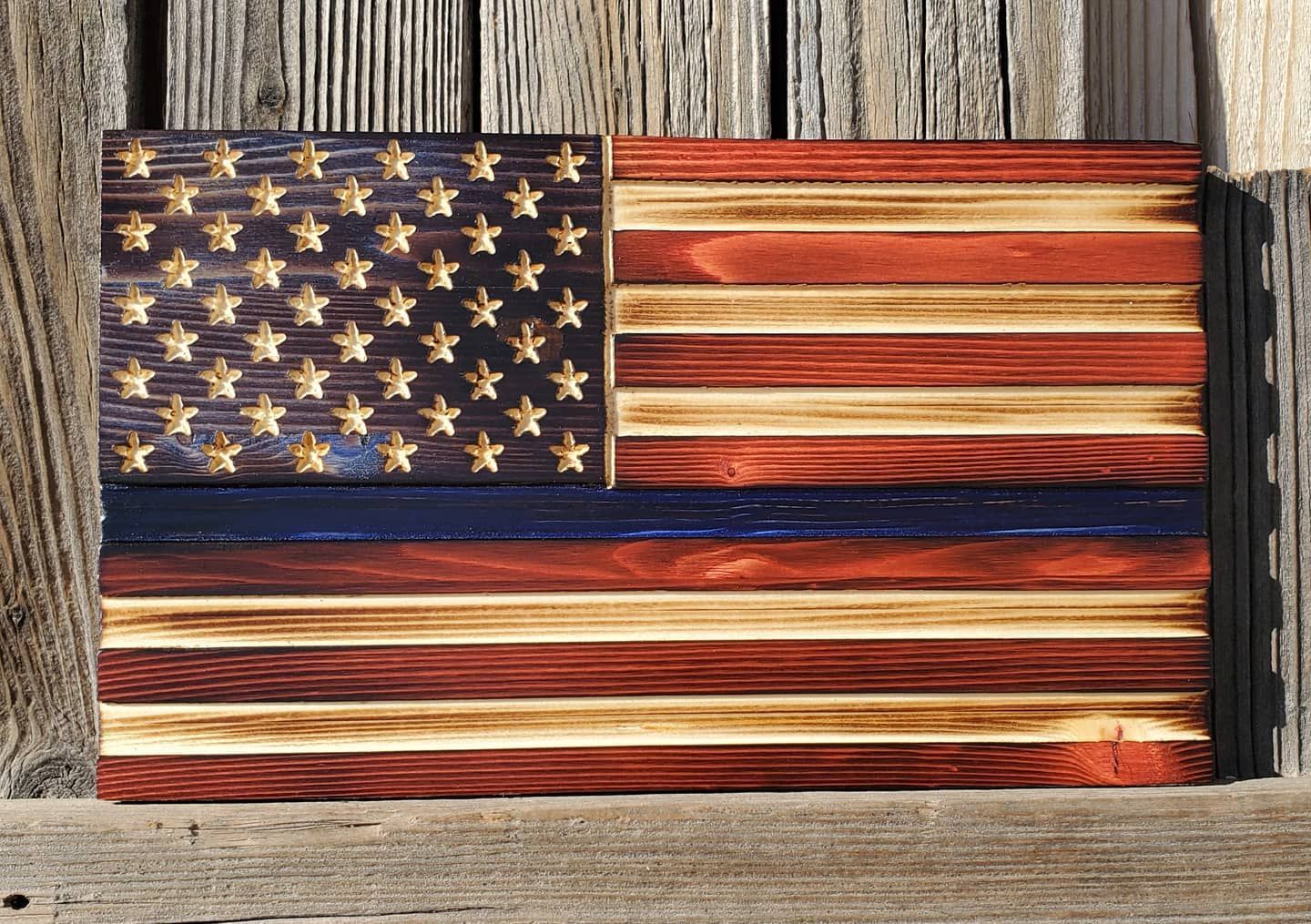 Wooden American flag with stars, blue stripes, and red stripes.