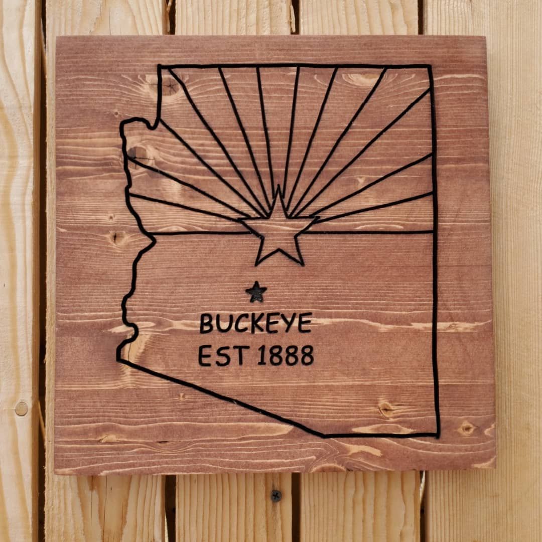 Wooden sign with Arizona outline, star, sun rays,