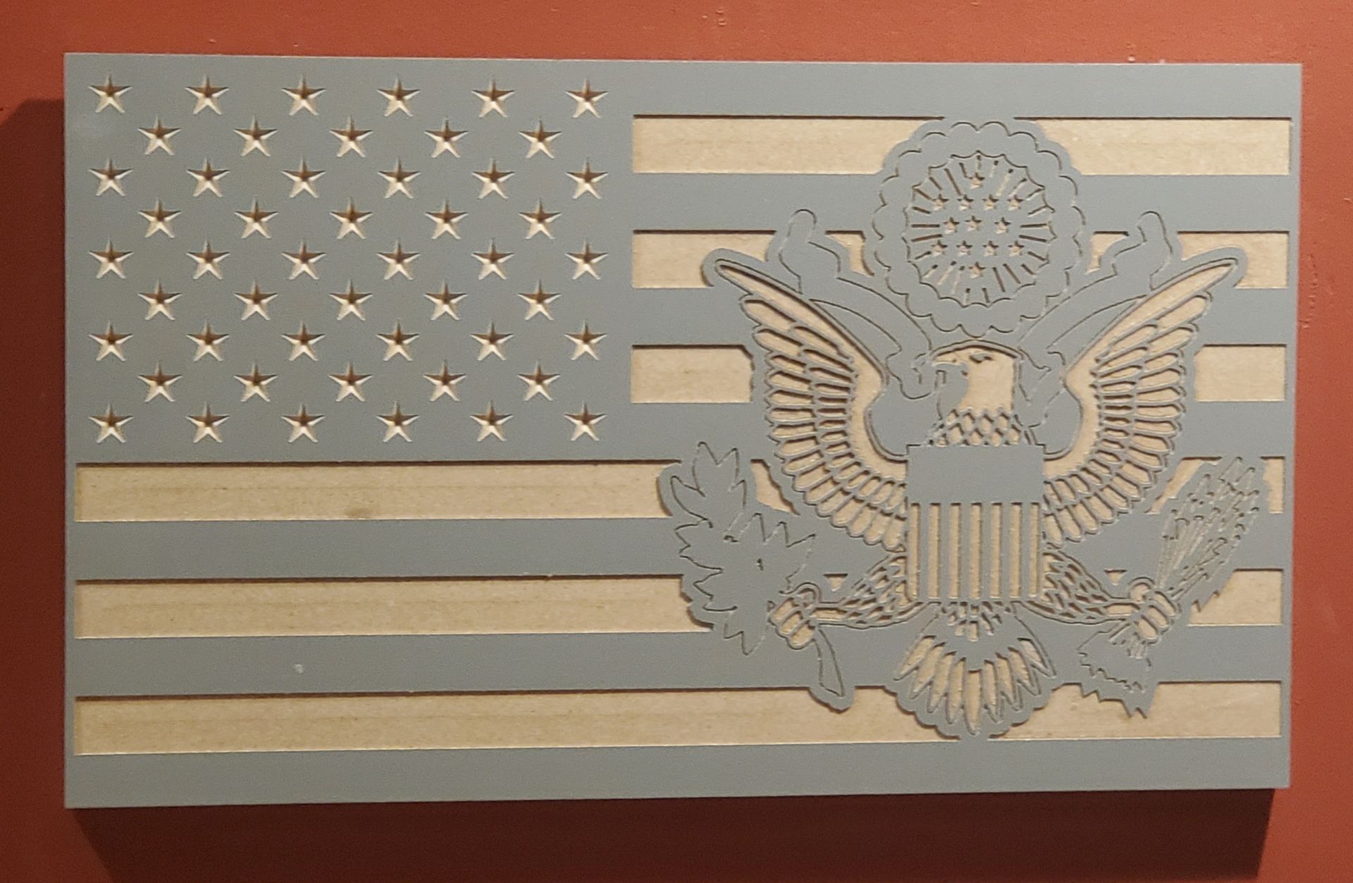 Wooden American flag with a detailed eagle emblem. Light blue and beige tones.
