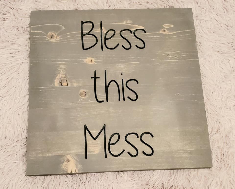 Wooden sign with grey stain reads