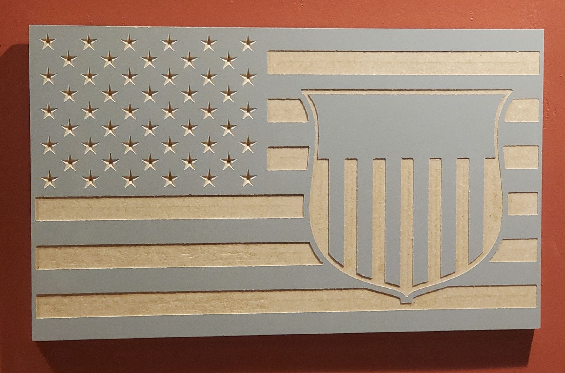 Wooden American flag with a shield design. Gray and natural wood colors.