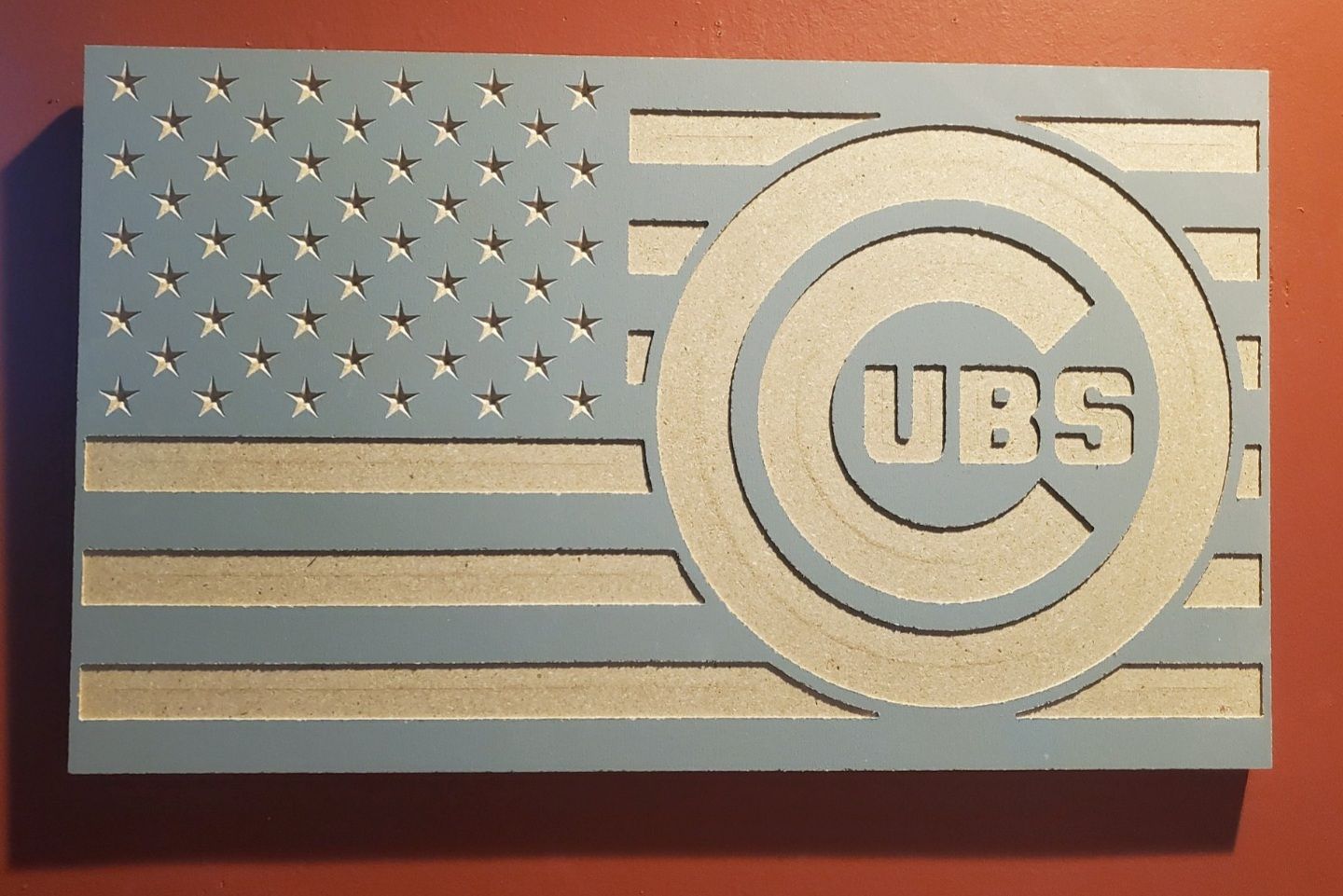 Wooden carving: American flag design with Chicago Cubs logo in blue and beige.