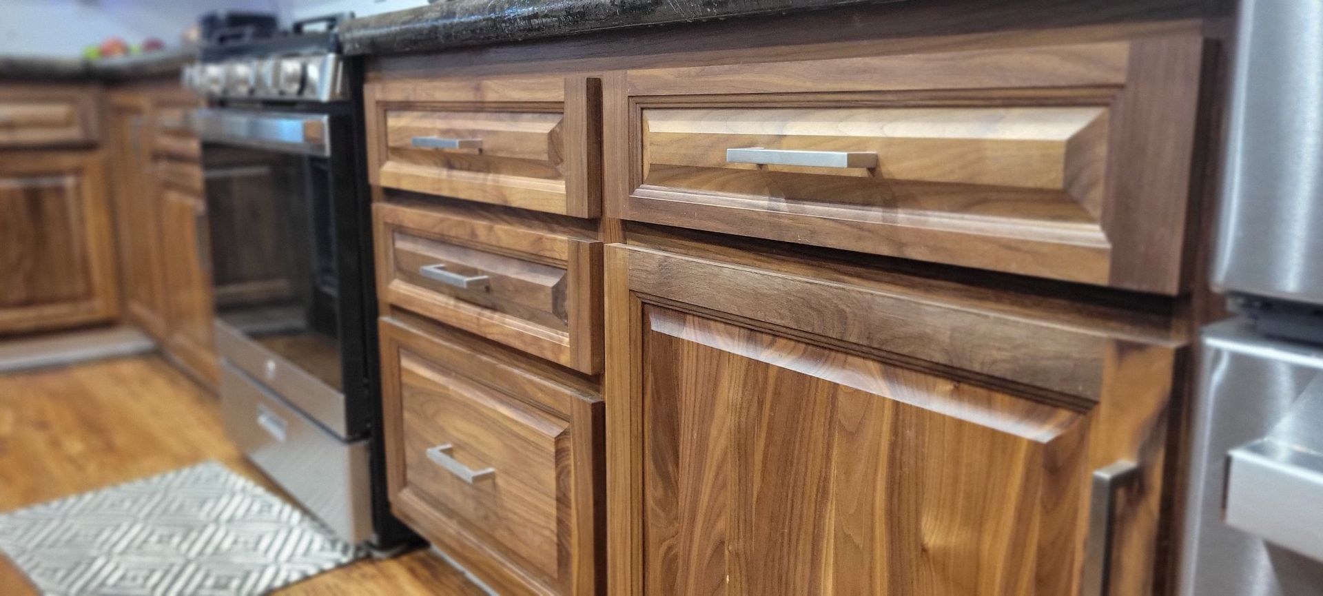 Wooden kitchen cabinets and oven with stainless steel appliances.