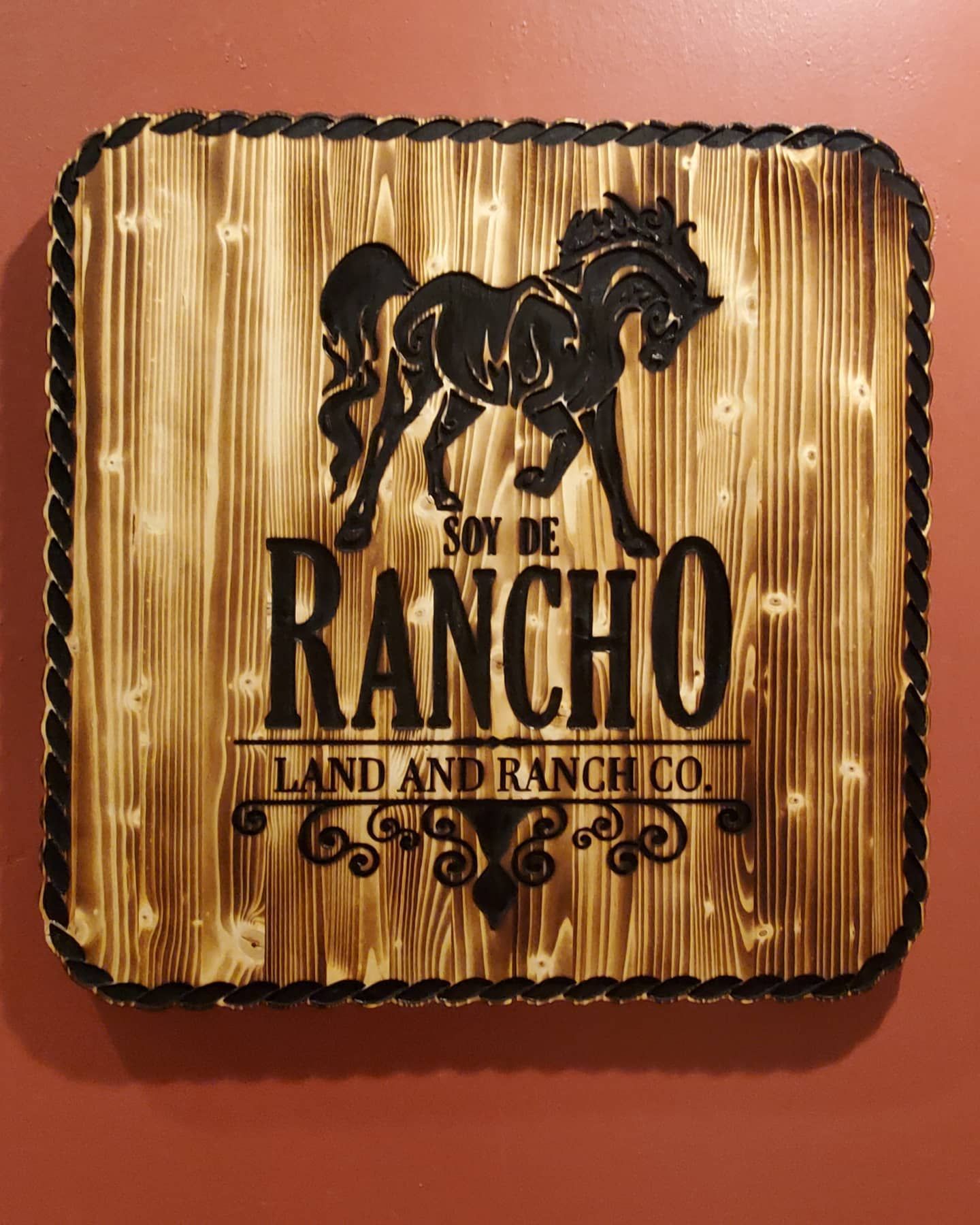 Wooden sign with a horse and text