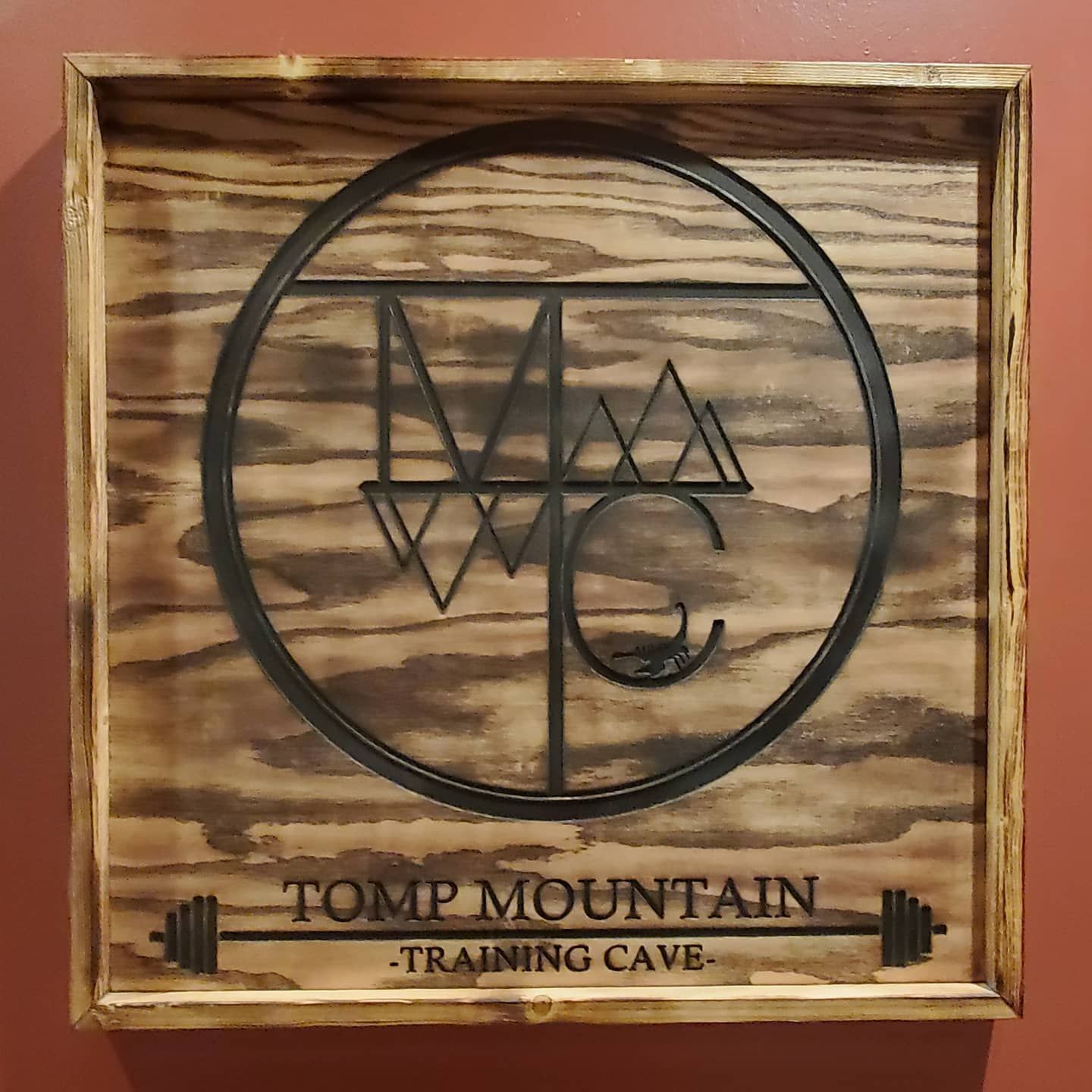 Wooden sign with a black circle surrounding stylized