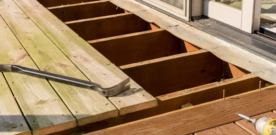 whole house remodeling clermont Deconstructed wooden deck with a crowbar resting on the boards.