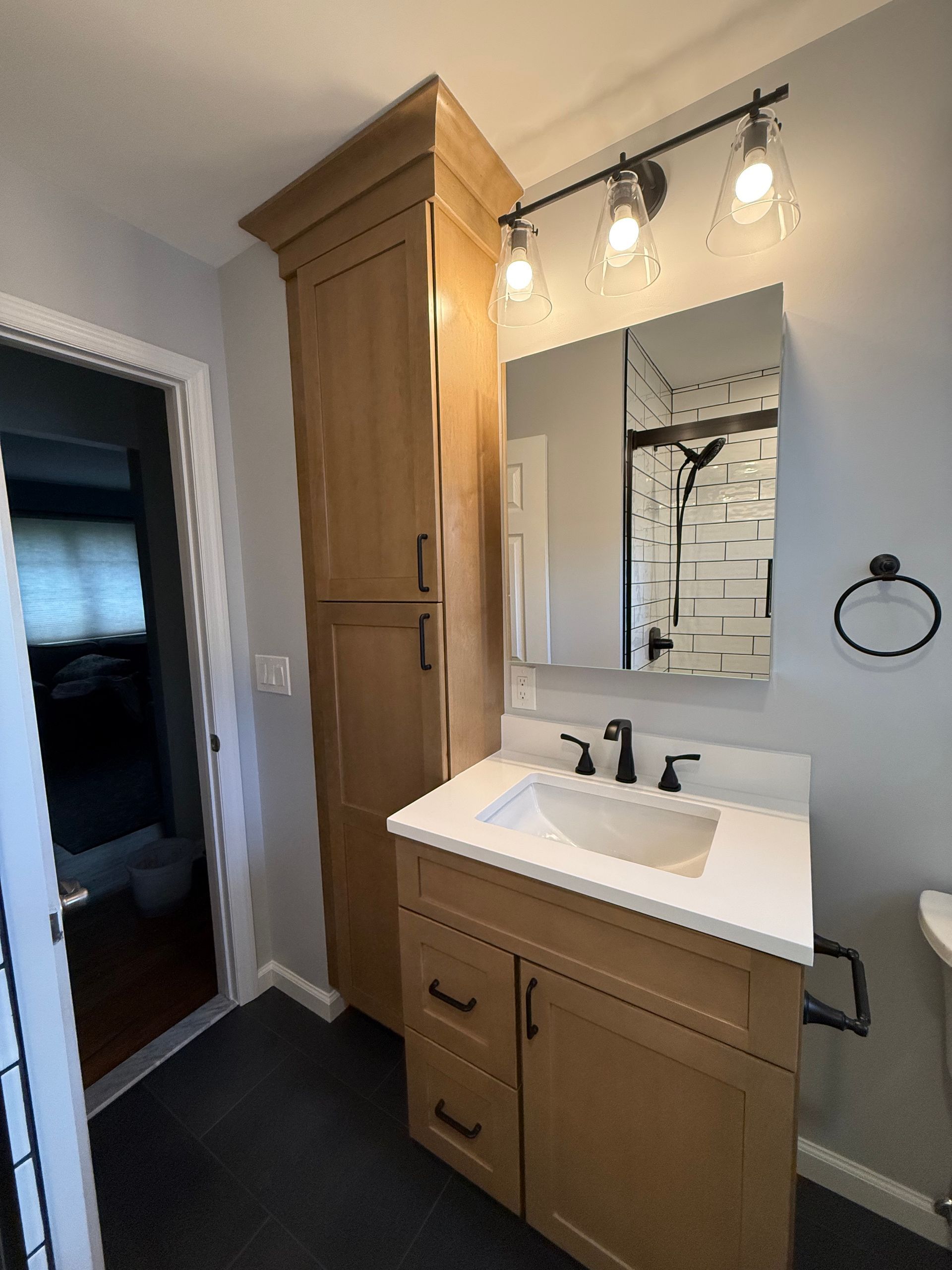 A kitchen in construction: white cabinets and island with exposed wood frames on a brown floor.