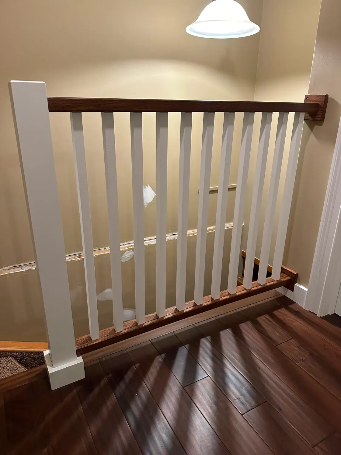 White and wood railing with vertical slats along a staircase.