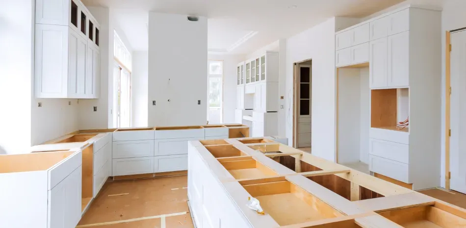 Kitchen cabinets during renovation, with wood and white surfaces.