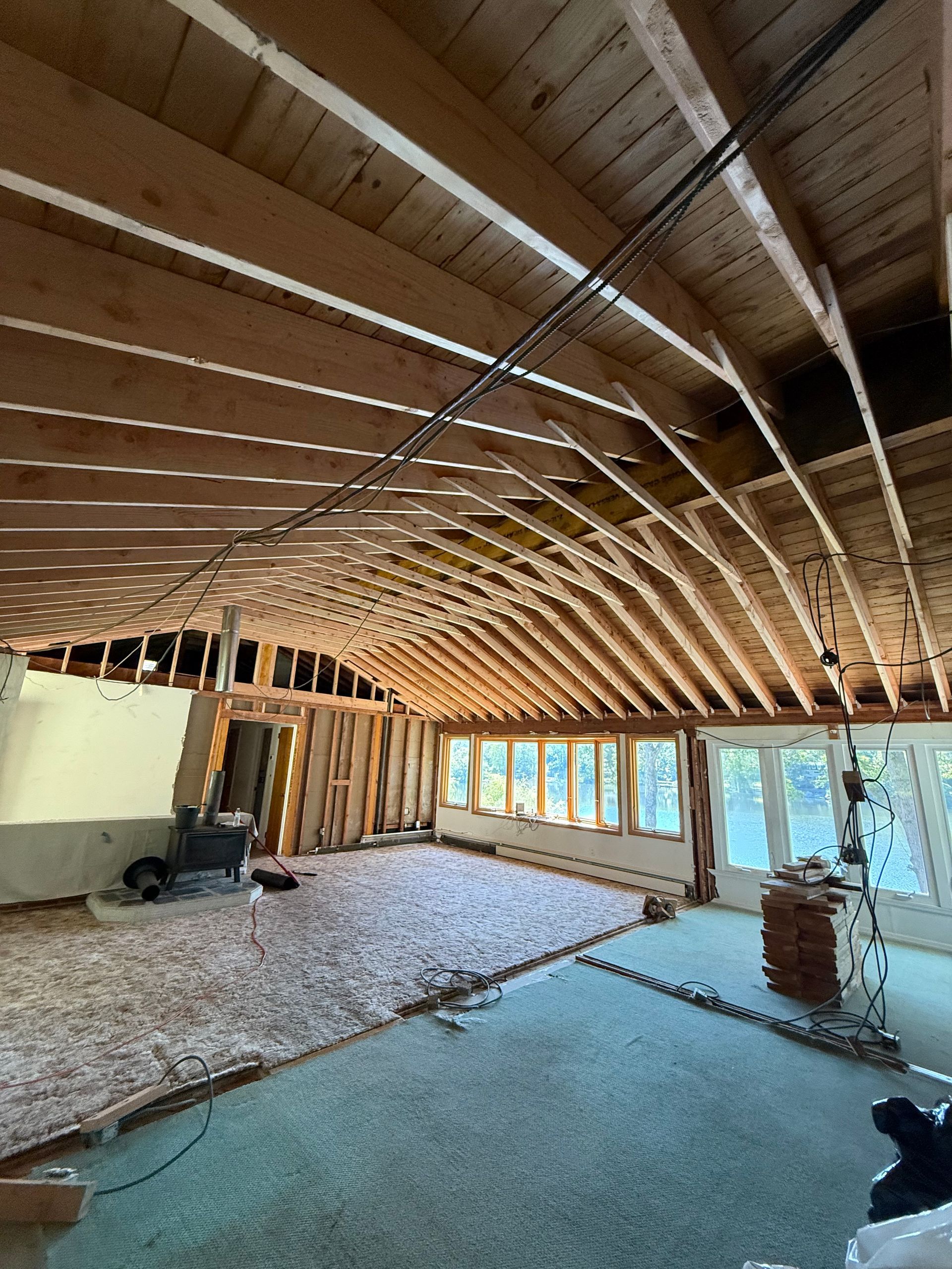 Interior of a house under renovation, revealing wooden beams and partially removed walls.