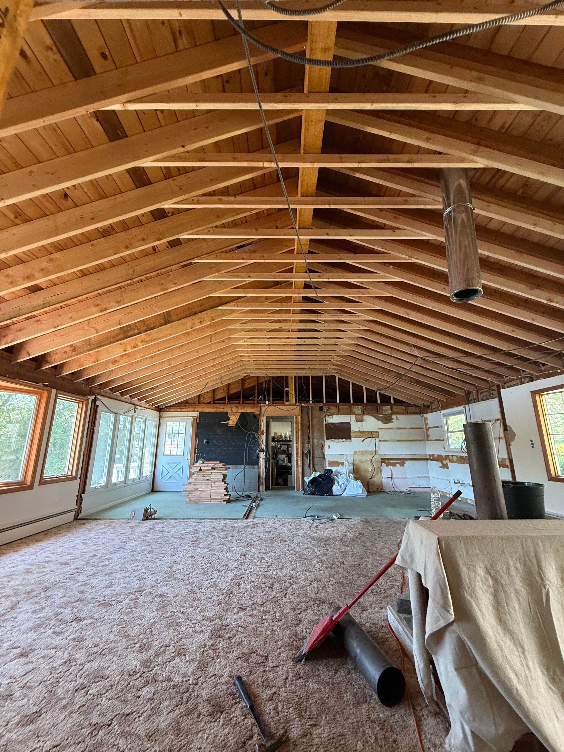 Interior of a building under construction, wooden rafters, insulation, windows.
