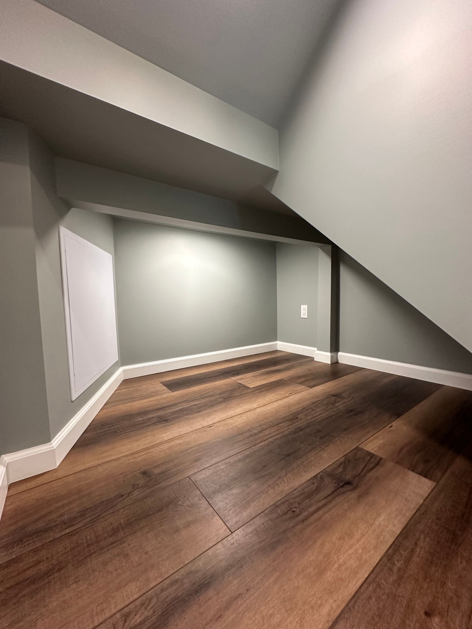 Small, finished alcove with gray walls, white trim, and wood-look flooring.