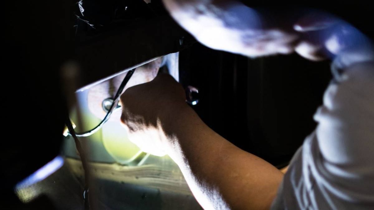a person is working in the dark with a flashlight