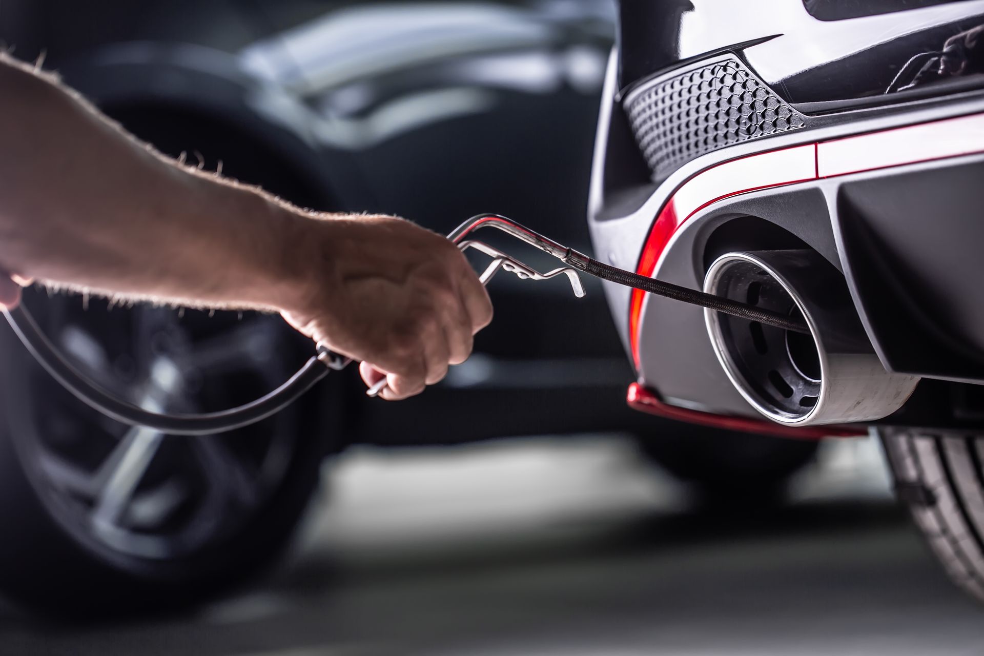 a person is working on the exhaust pipe of a car