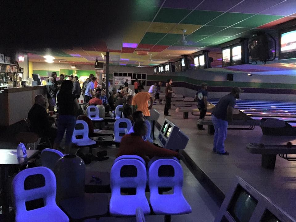 A group of people are playing bowling in a bowling alley