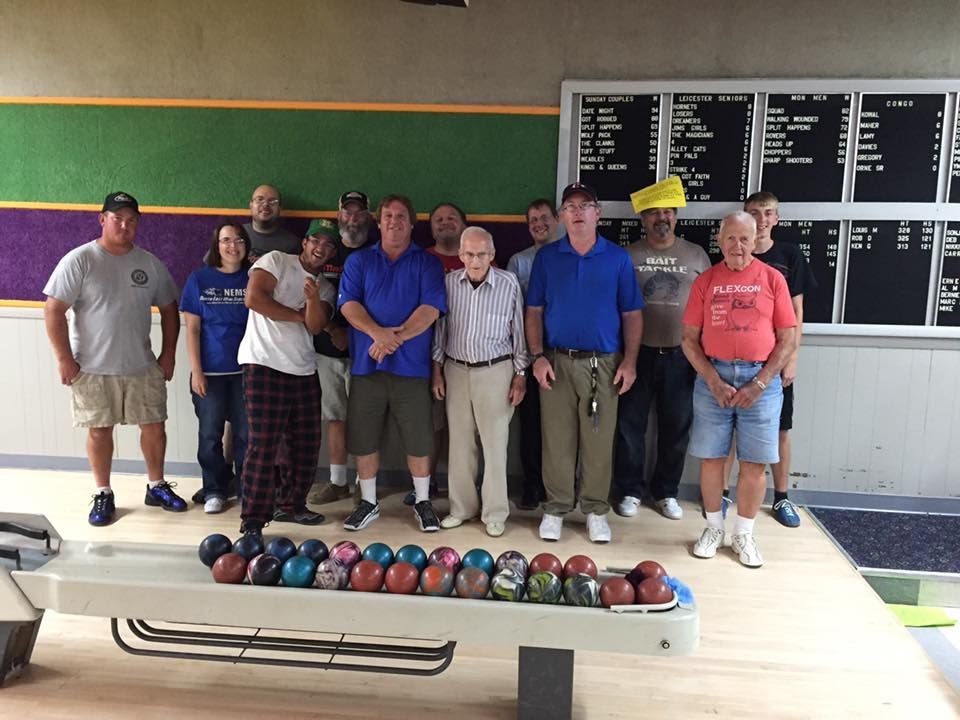 A group of people standing in front of a bowling alley