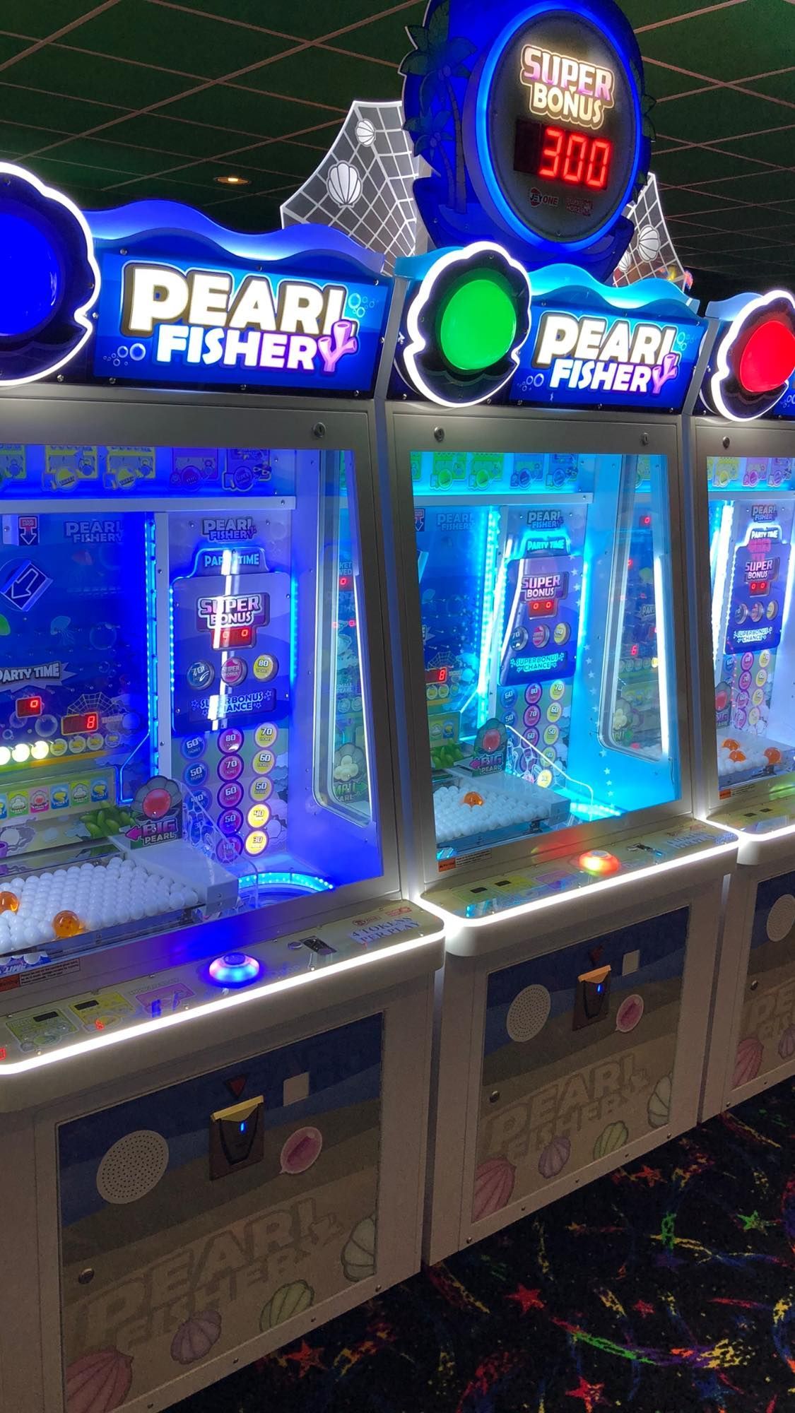 A row of arcade games are lined up in a room.