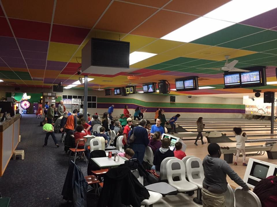 A group of people are playing bowling in a bowling alley