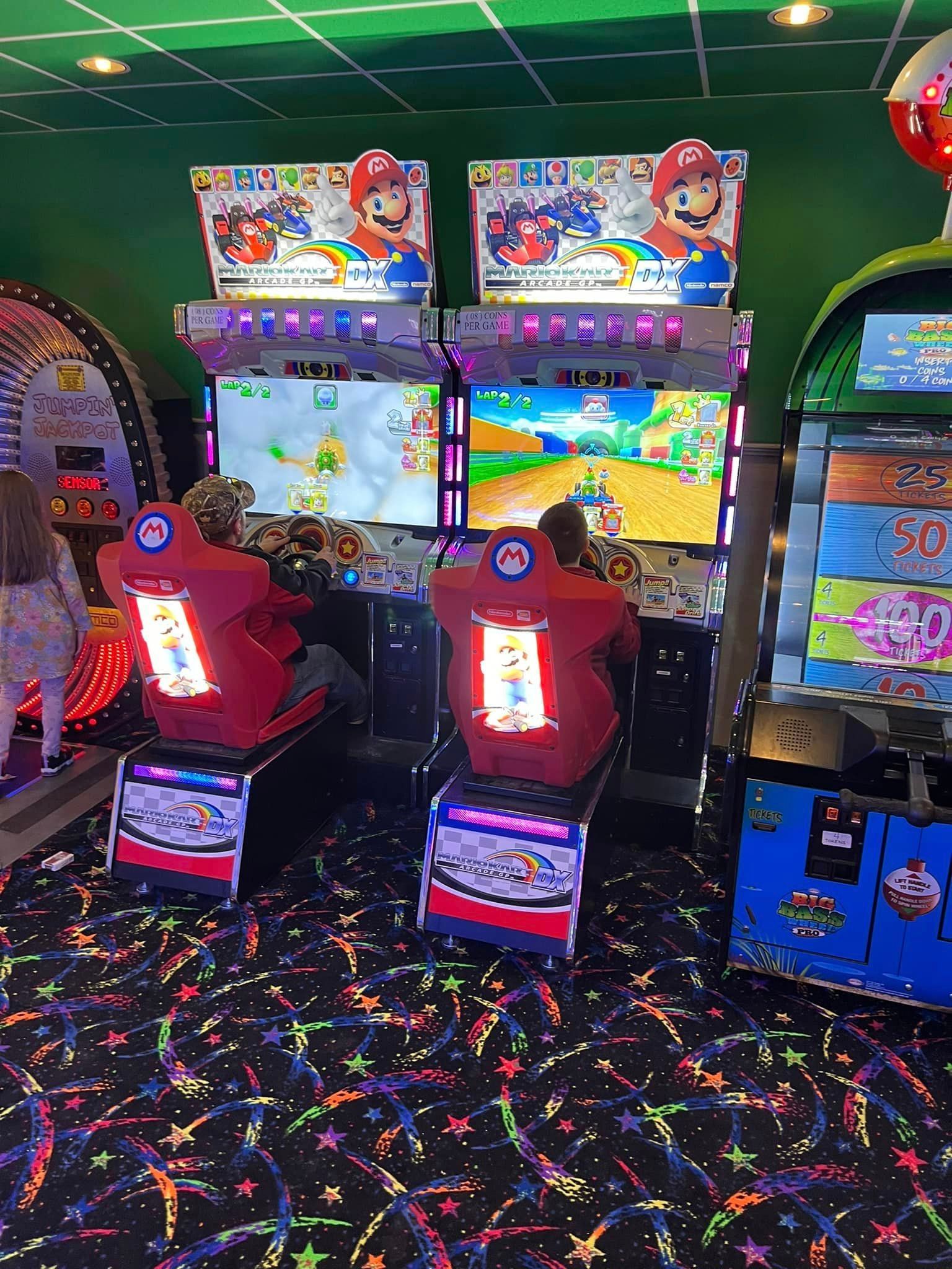 A couple of arcade games are sitting in a room.