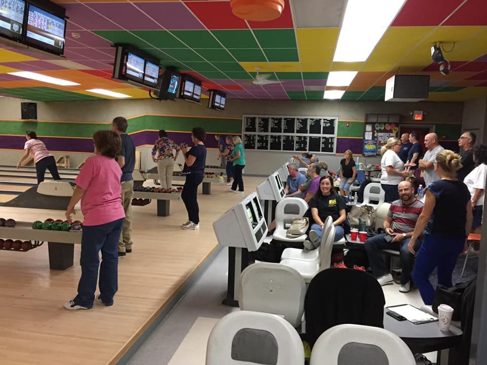 A group of people are playing bowling in a bowling alley