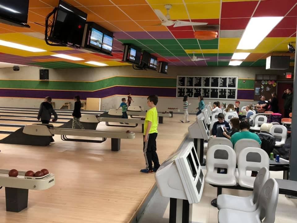 A group of people are playing bowling in a bowling alley