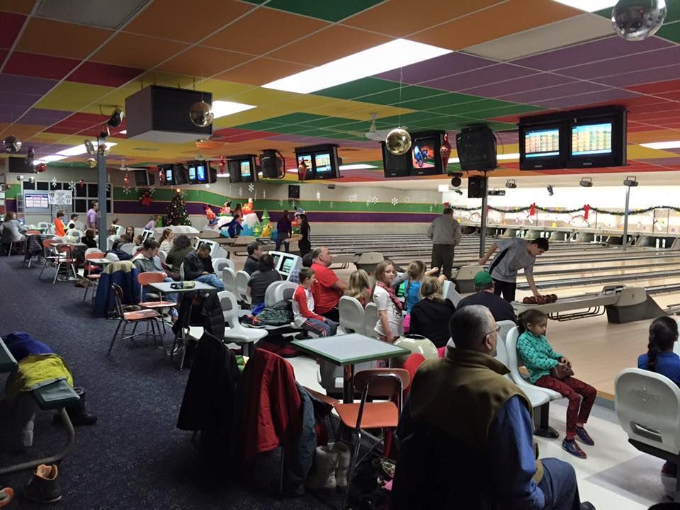 A group of people are playing bowling in a bowling alley