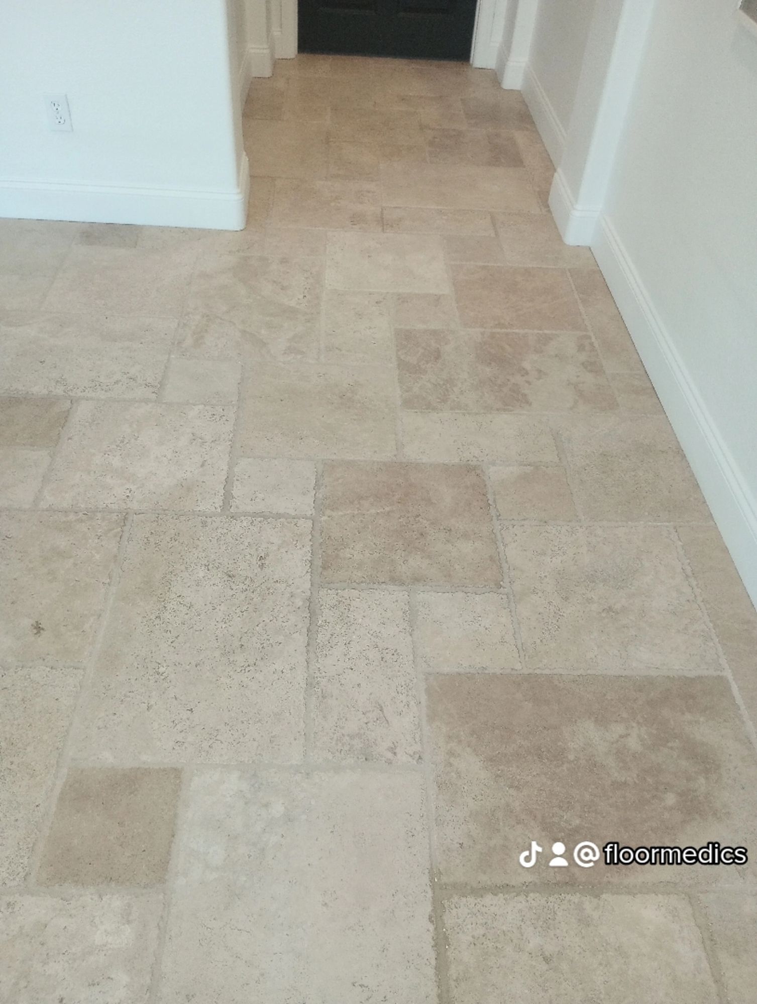 A hallway with a tiled floor and white walls