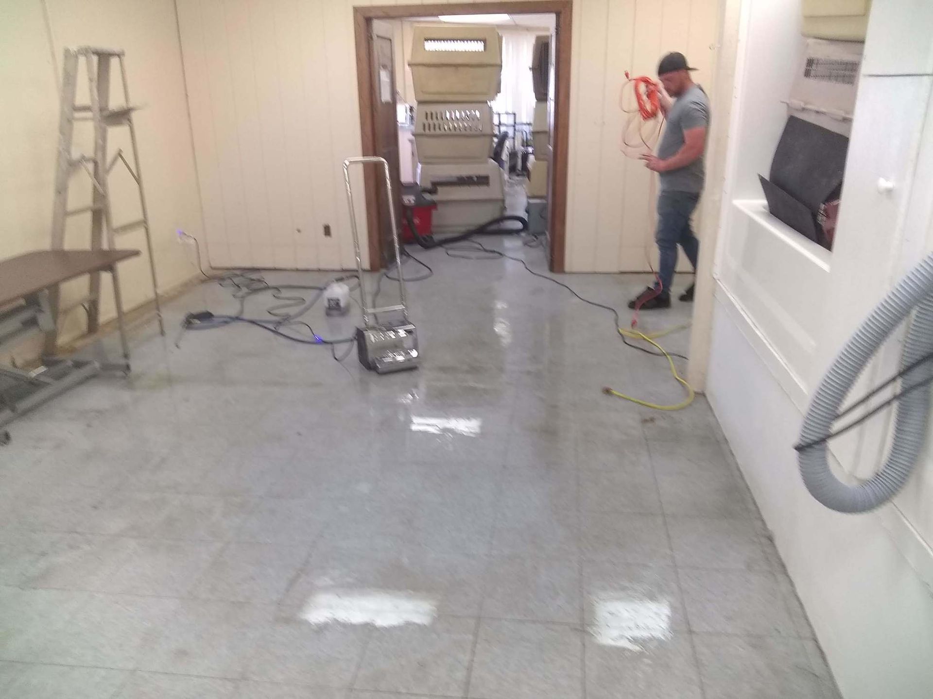A man is standing in a room with a vacuum cleaner on the floor