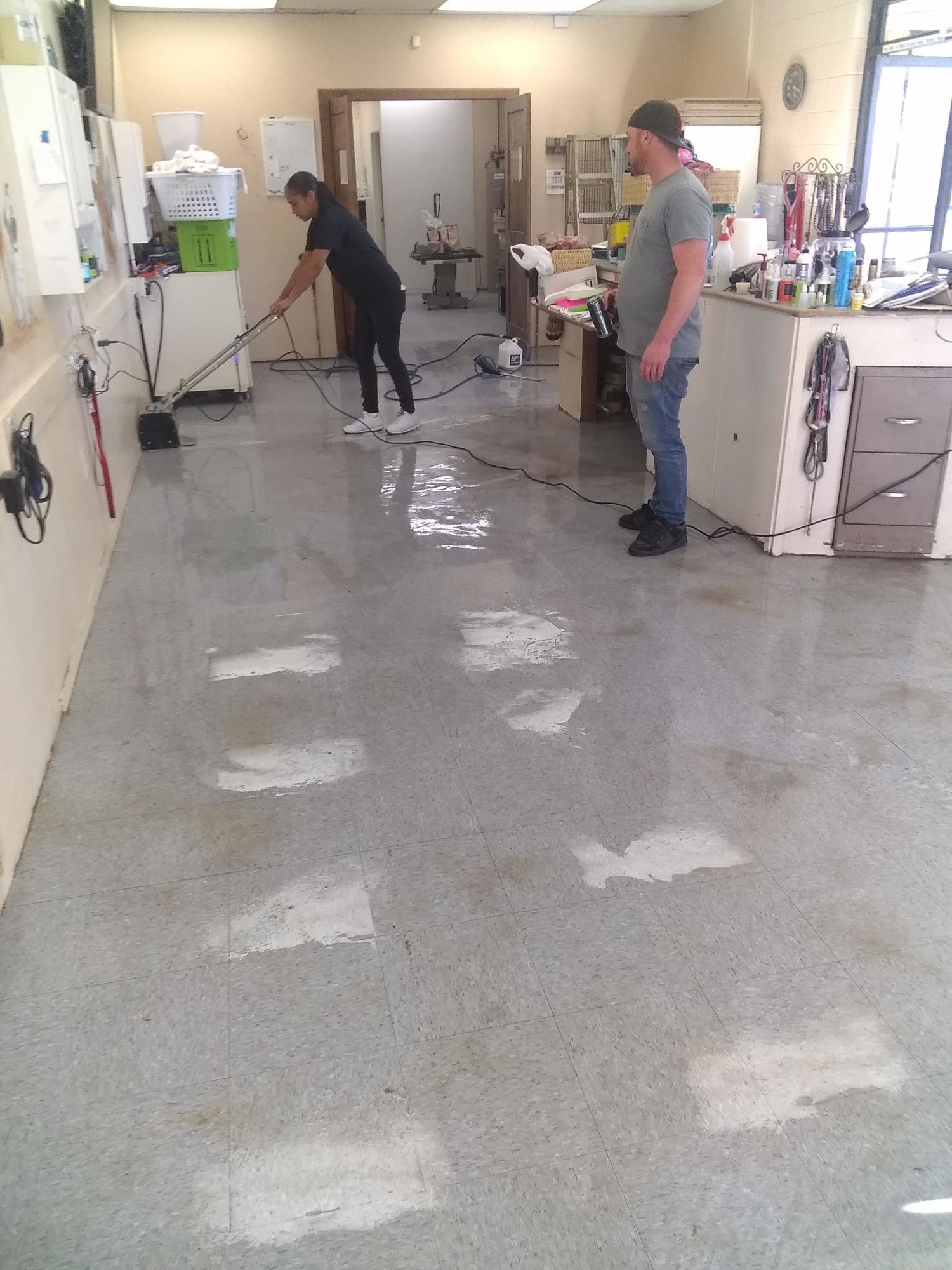 A man is cleaning the floor of a room with a vacuum cleaner.