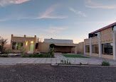 Beige buildings with a courtyard and dusk sky.
