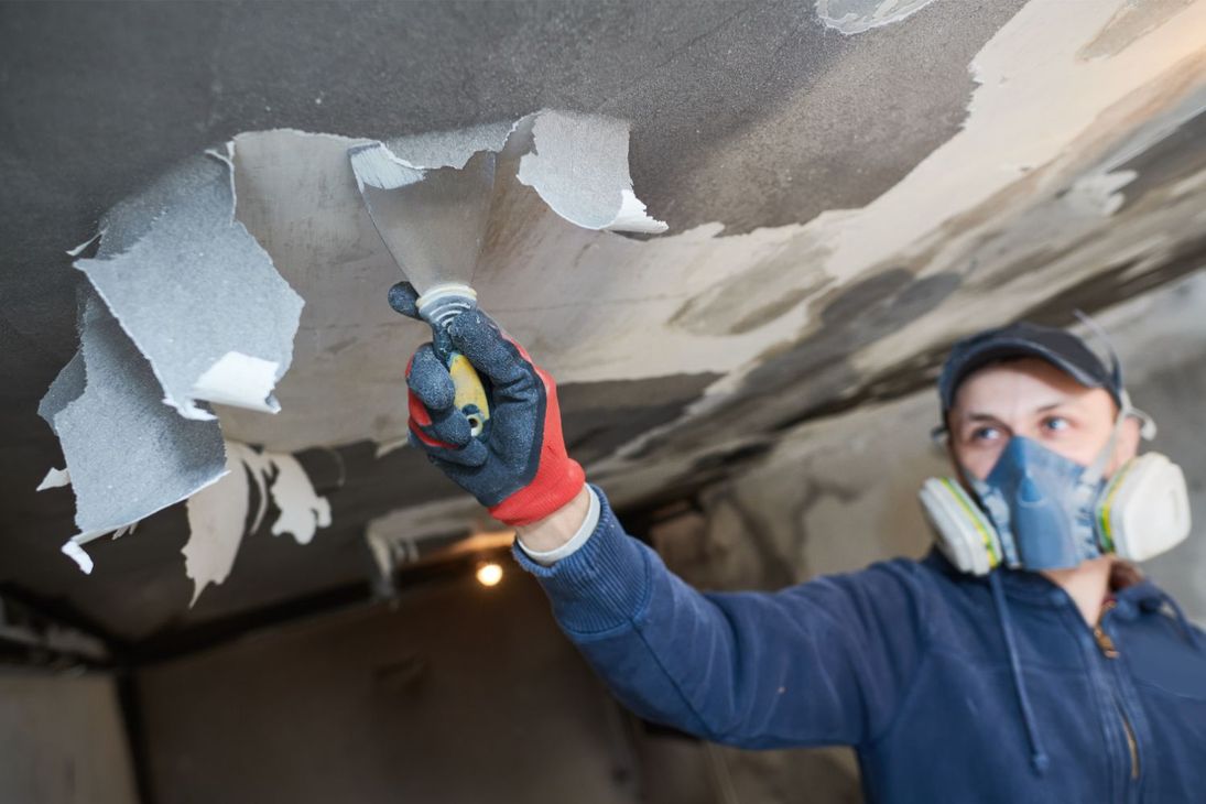 A blue house with a broken roof and a broken window