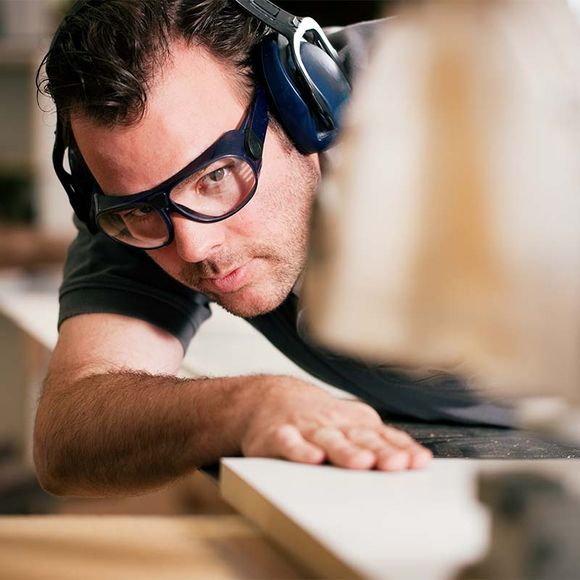 Carpenter Cutting Wood In A Thicknesser