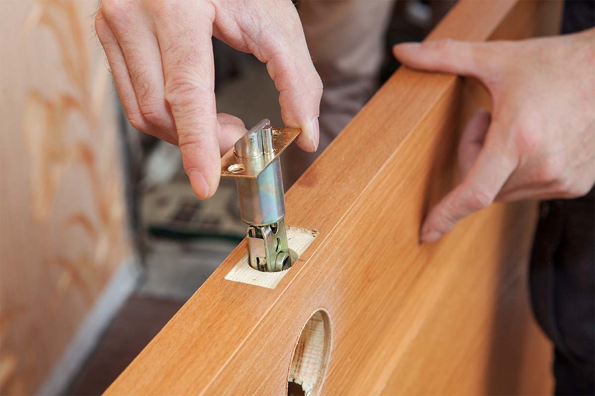 Experienced Carpenter Installing A Lock In A New Timber Door