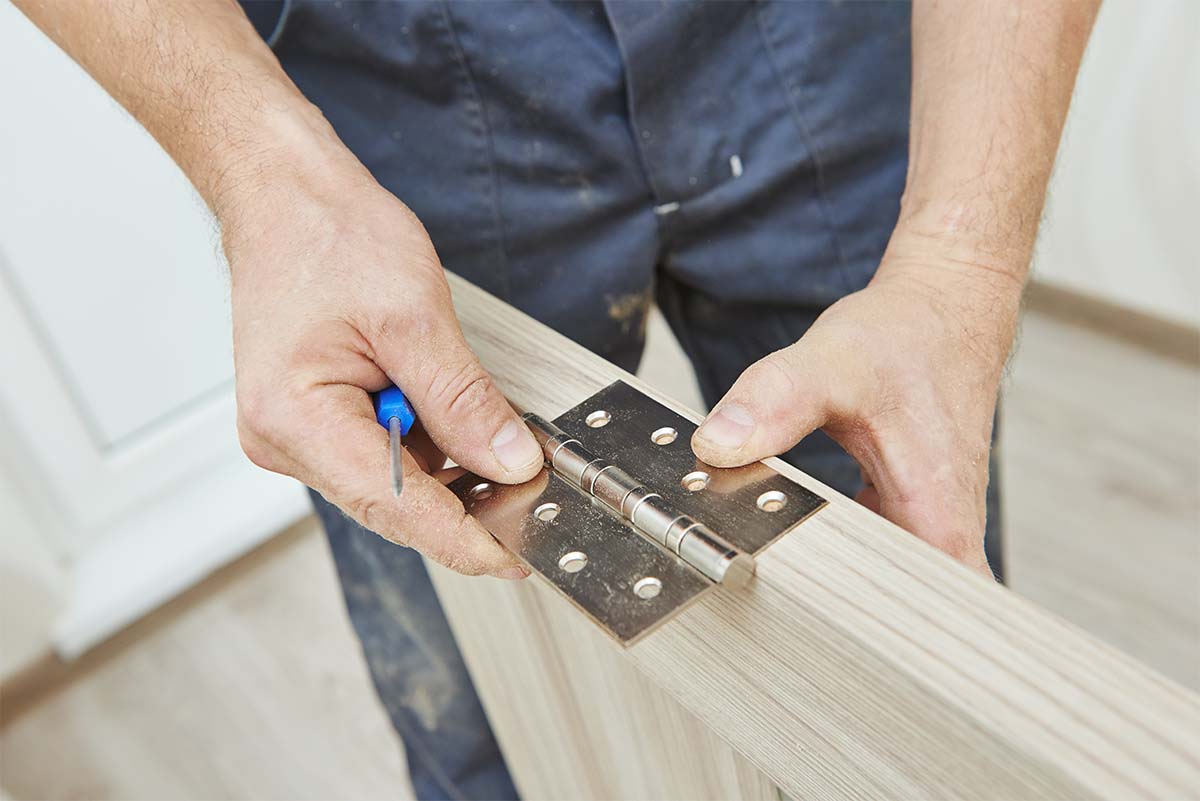 Local Carpenter Installing A Door Hinge