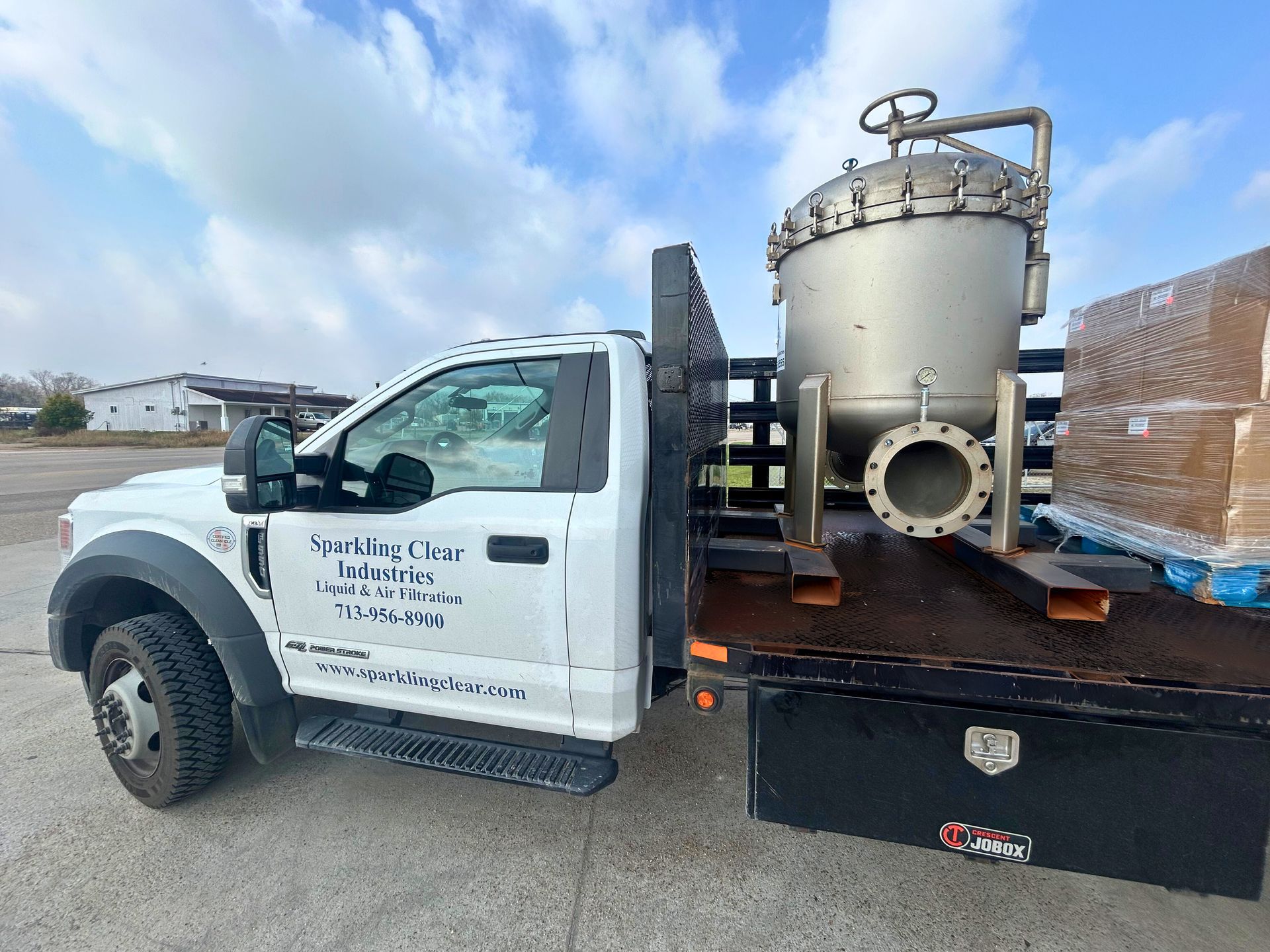 Sparkling Clear Industries truck delivering a 12-round industrial bag filter housing rental to a chemical manufacturing facility on the Houston Ship Channel.