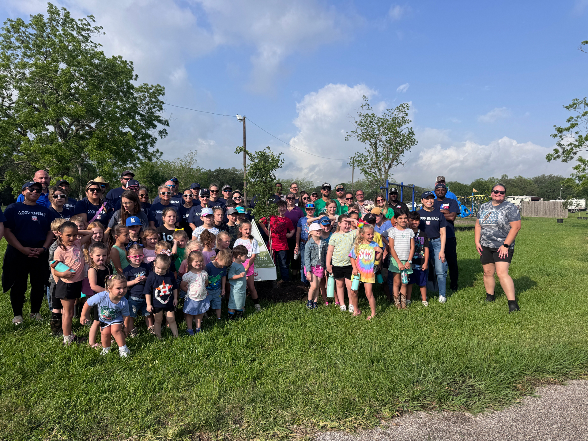 A large group of people are posing for a picture in a grassy field.