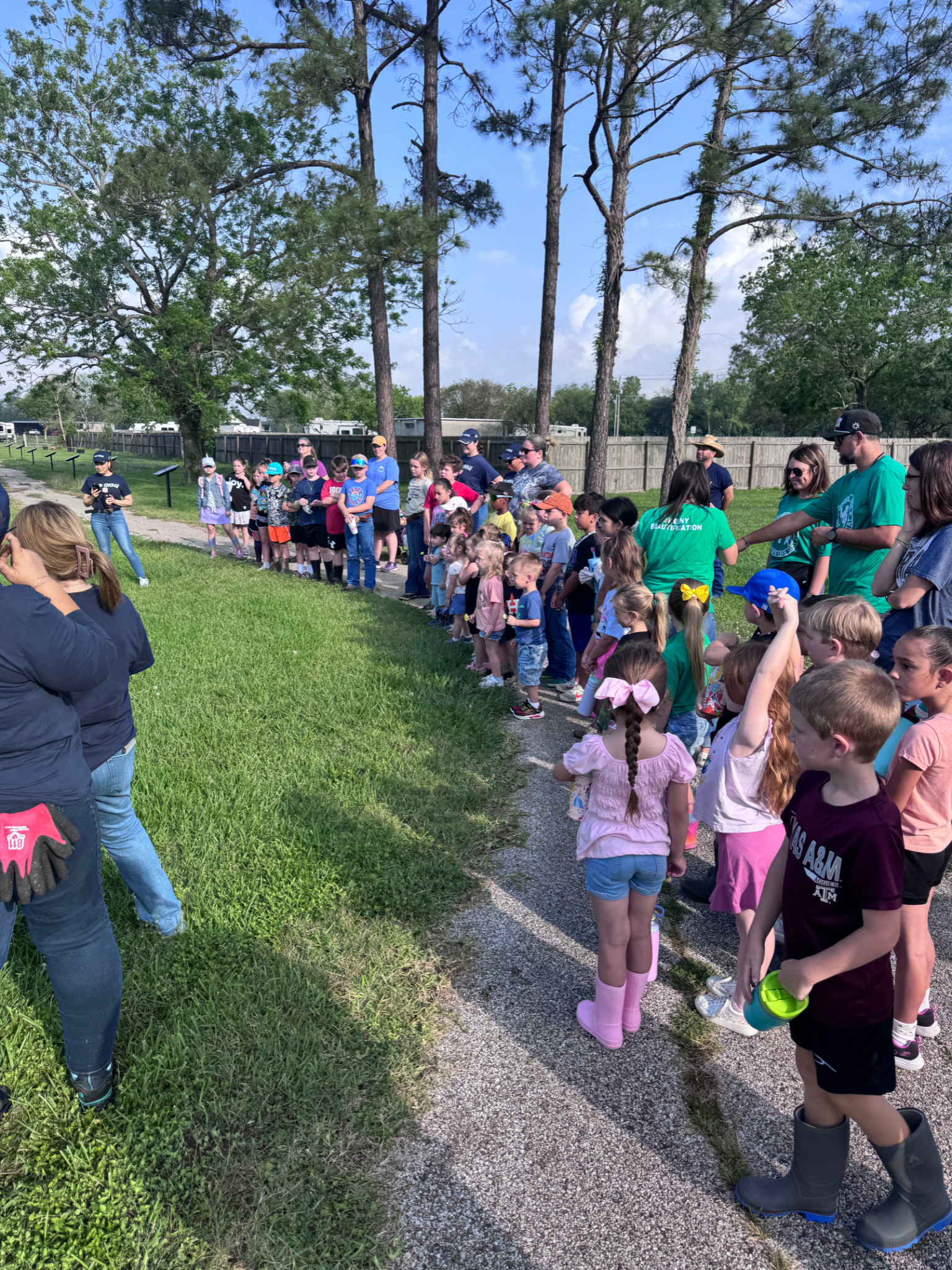 A group of children are standing in a line in a park.