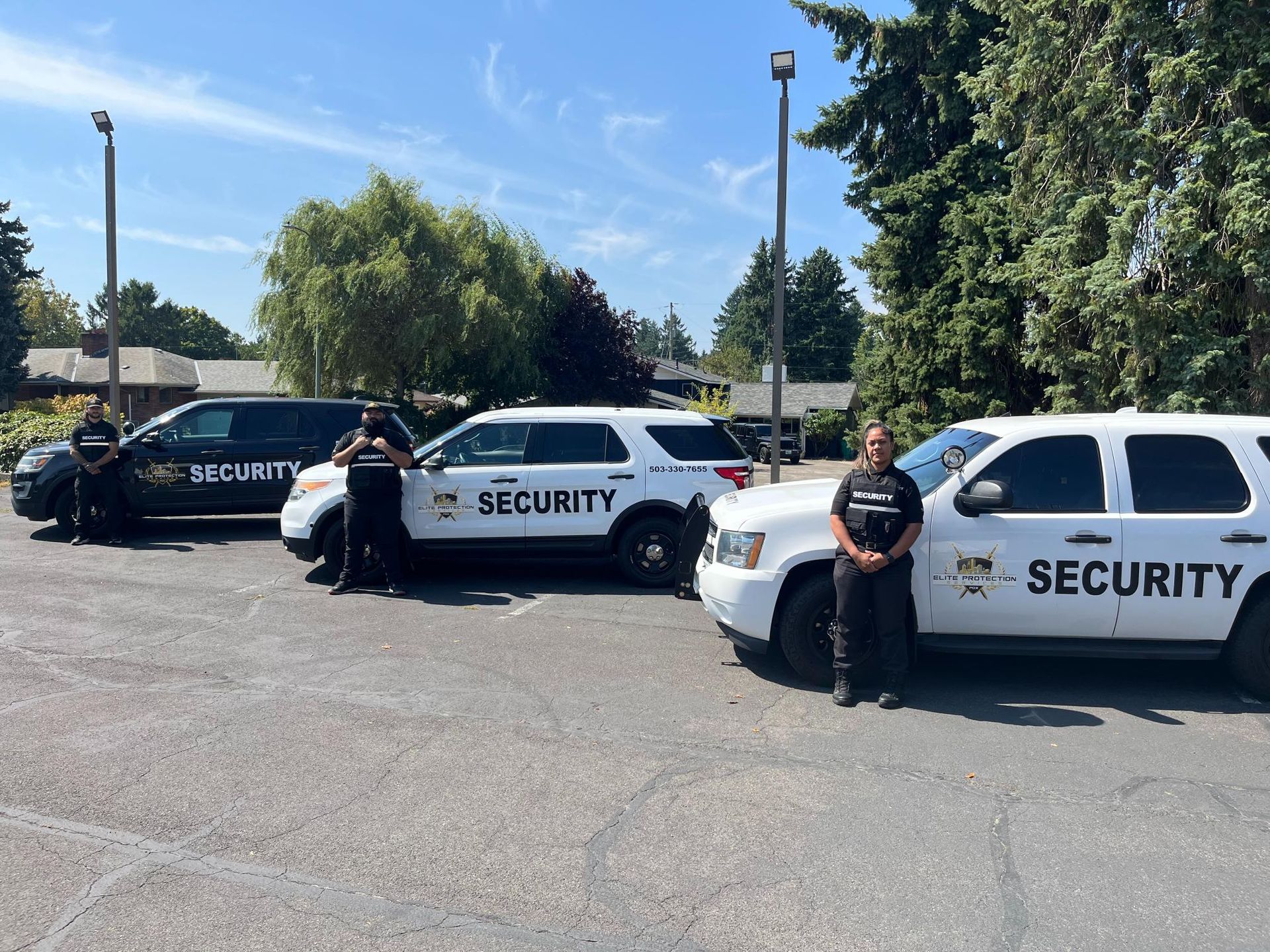 Security vehicles and guards parked in a lot on a sunny day