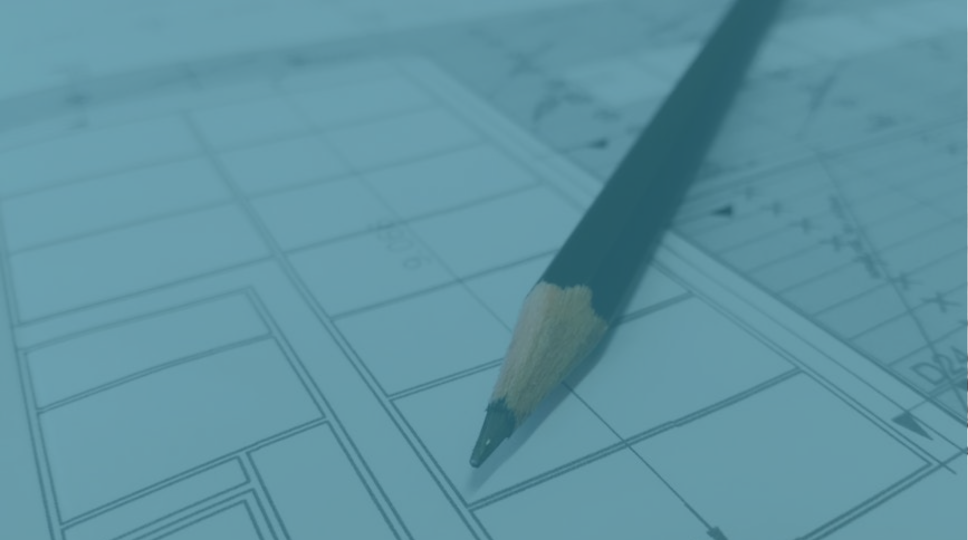 Pencil sketching a floor plan on blue architectural blueprints