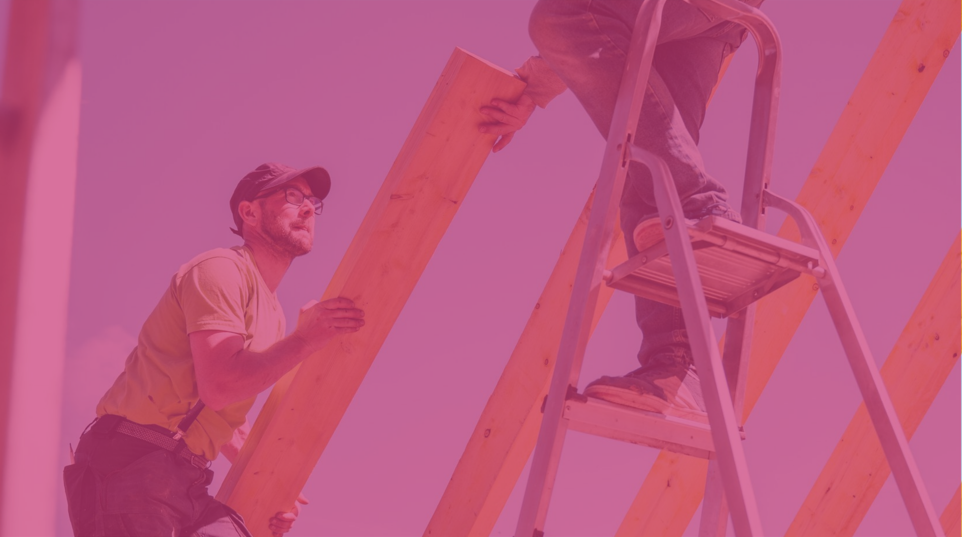 construction workers on a ladder assembling a wooden frame against a pink sky