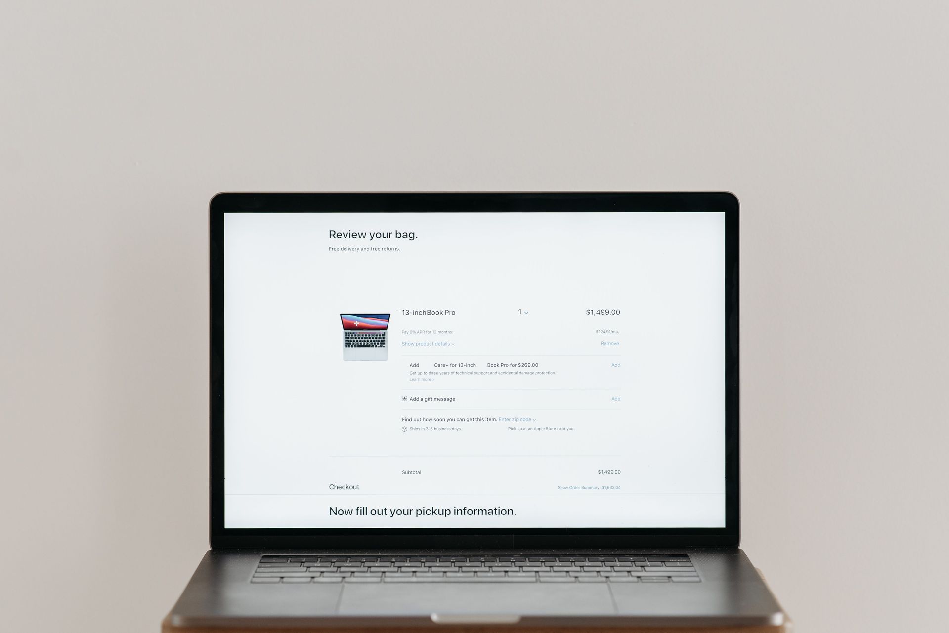 Laptop displaying a bright webpage on a desk against a plain wall