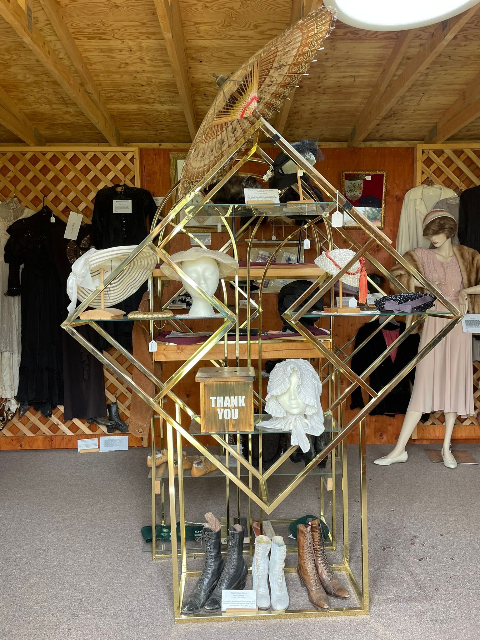 A display of clothes and shoes in a store with mannequins.