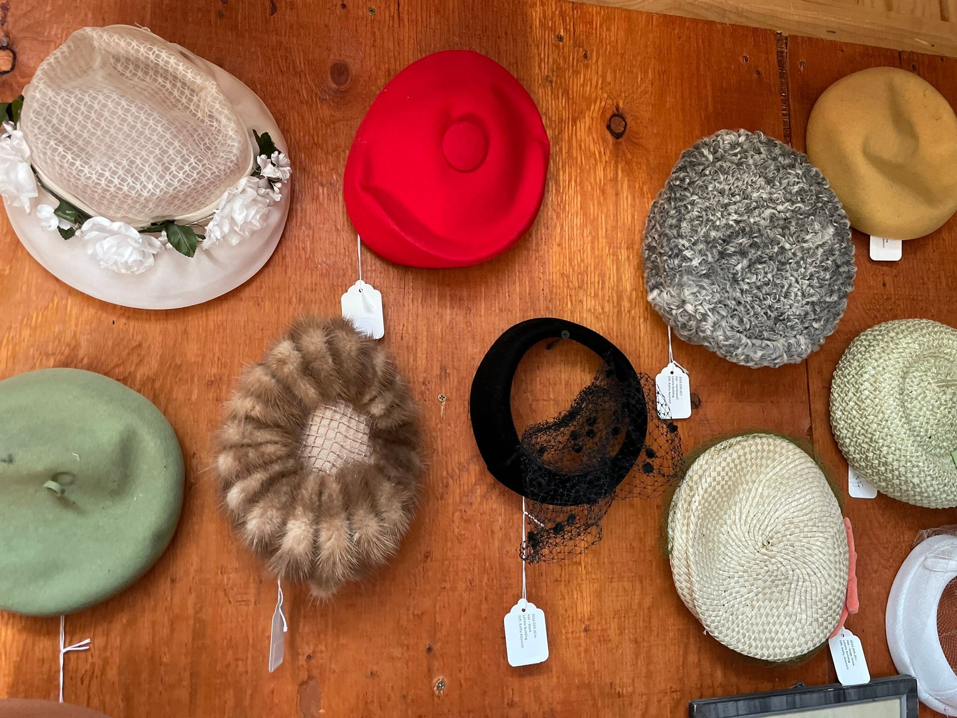 A bunch of hats are hanging on a wooden wall