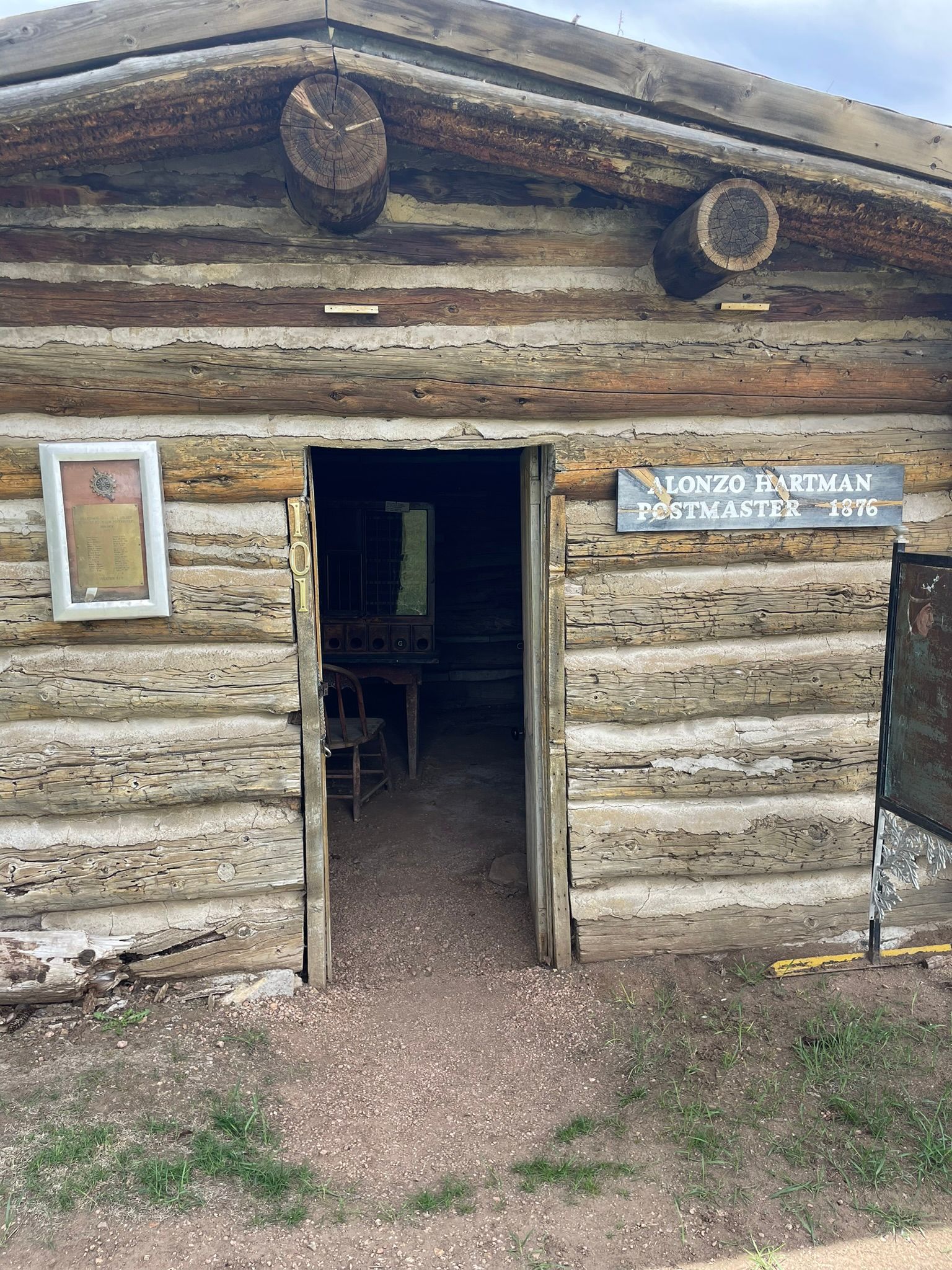 A log cabin with a sign on the side of it.