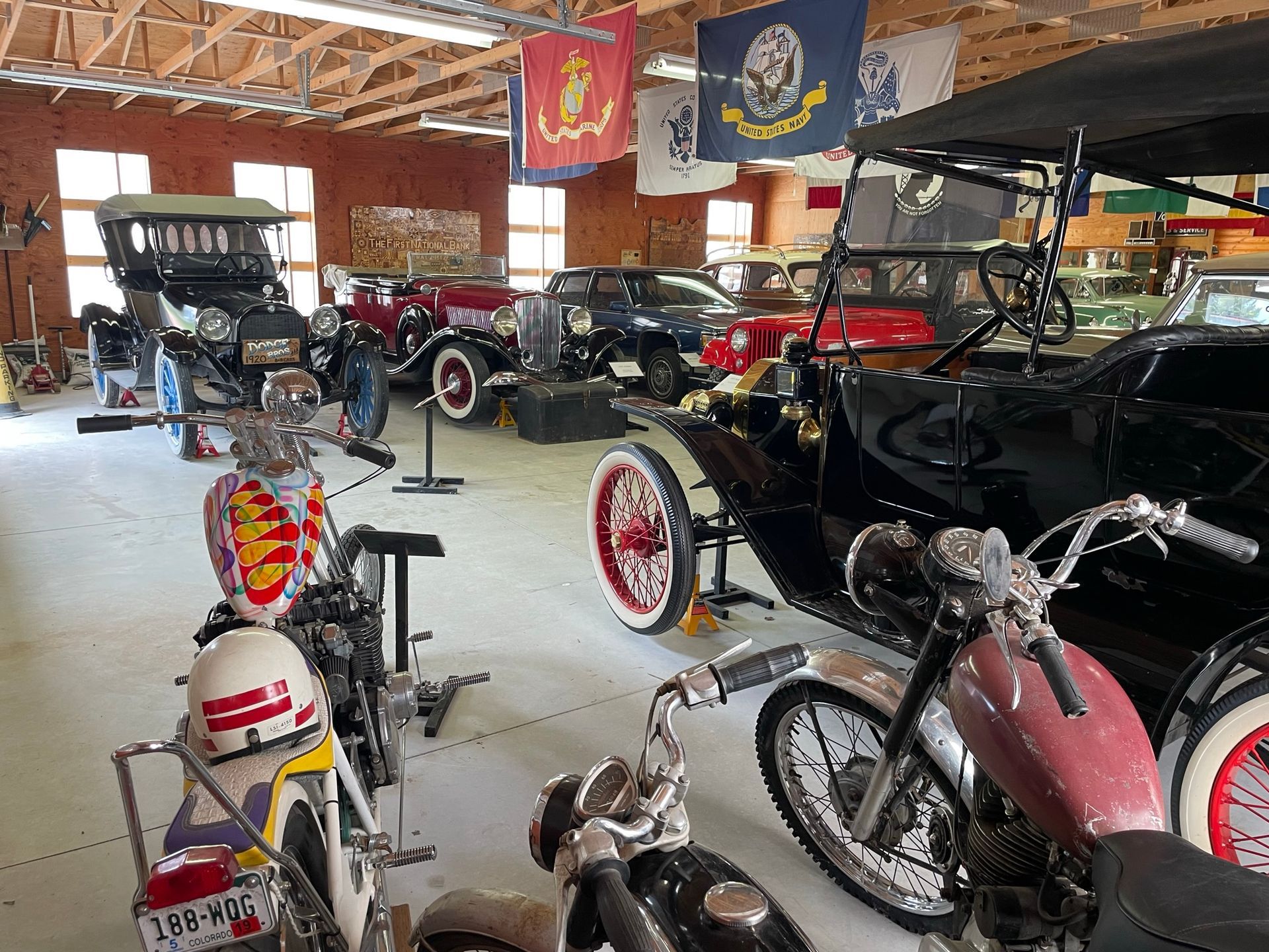 A garage filled with lots of old cars and motorcycles